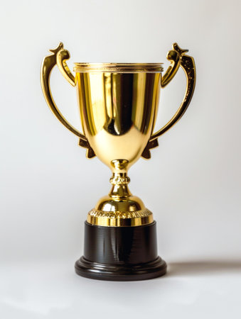 A golden trophy cup with handles on a black base, suggesting a prize for a competition or achievement, against a white backgroundの素材