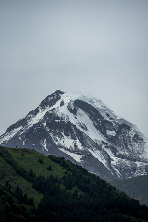 Mountain landscape with snow and clouds.