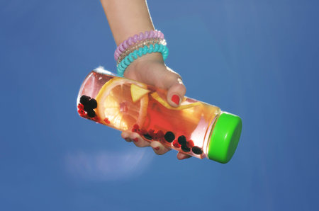 A drink with lemon and berries in the bottleの写真素材