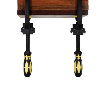 clamps of yellow color hold wooden bars on a white background. Use F-clamp to holding or catch wood in woodworking.の写真素材