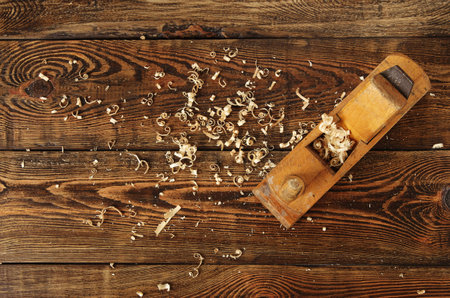 old planer and shavings on dark wooden table, top viewの写真素材