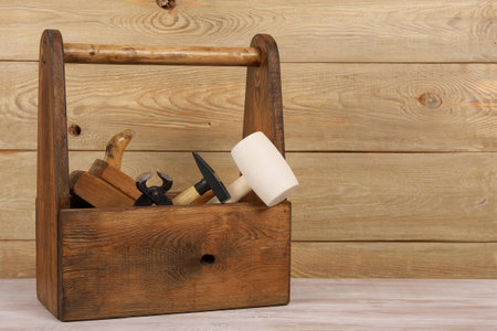 wooden box of carpenter tools on the table, near wallの写真素材