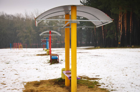 vivid benches on the beach in winter. deserted river beach in the city. serenity and emptiness.の写真素材