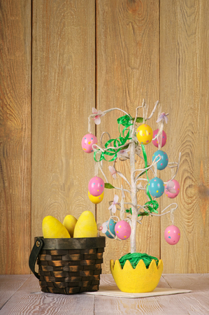 Easter tree on abstract background.eggs painted in wicker basketflowers, handmadeの写真素材