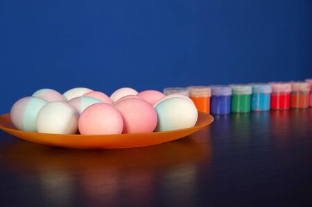 painted Easter eggs and paints on the table. preparation for Easter. dark wooden table.の写真素材