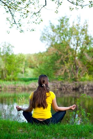 girl sitting on the bank of the riverの写真素材