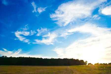beautifull landscape with sun, sky, clouds and meadowの写真素材