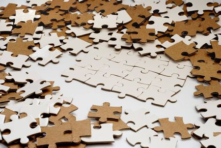 heap of white and brown puzzle piecesの写真素材