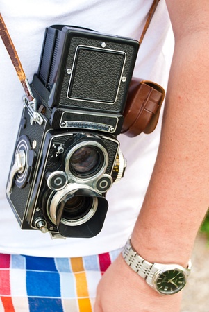 old camera hanging on the shoulder of a man