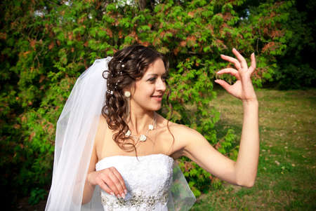 bride holding ring in a gardenの写真素材