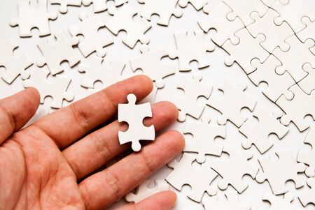 hand holding single puzzle pieceの写真素材