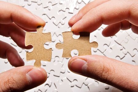 two hands holding puzzle pieces