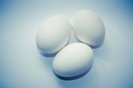 three eggs on a blue backgroundの写真素材