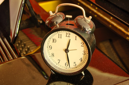 clock on the black pianoの写真素材