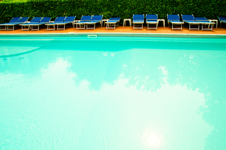 pool with chaise-longues in hotelの写真素材