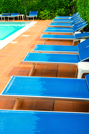 pool with chaise-longues in hotelの写真素材