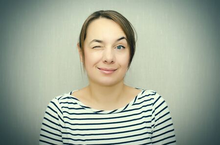 studio portrait of a happy winking woman