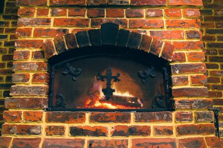 old stone fireplace brightly burningの写真素材