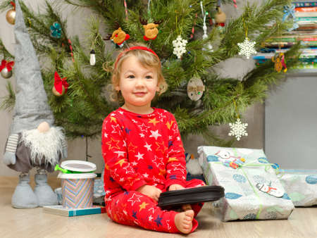 little boy unpacking gift under christmas tree
