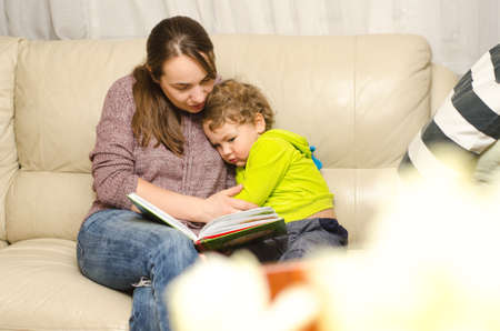 mother and child reading book at home