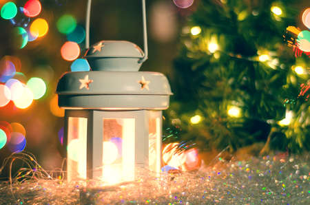 christmas lantern with green tree and blurred garland lightsの写真素材