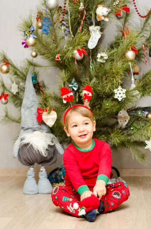 happy little boy sitting under the christmas treeの写真素材