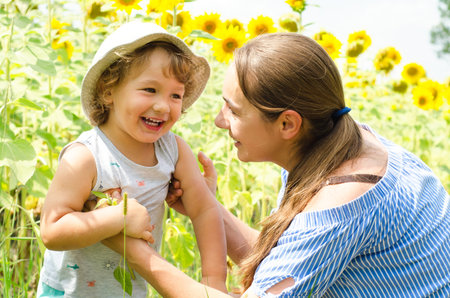 mother and baby in sunflowers fieldの写真素材