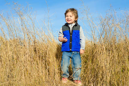 smiling little boy on a rural fieldの写真素材