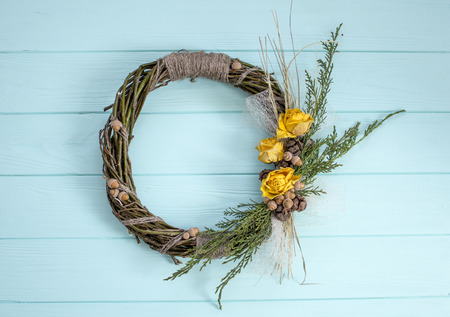 Wreath from a vine with roses. Handmade decor.Wreath of real twigs on a wooden backgroundの写真素材