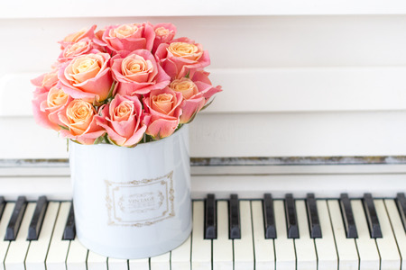 Roses in a Hat Box. Beautiful pink roses in a round box on the piano. の写真素材