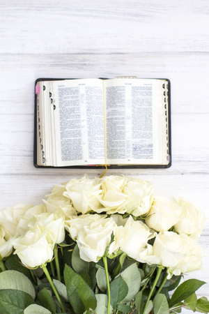 White roses and the Bible. White roses and the Bible on a white wooden backgroundの写真素材