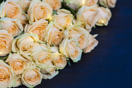 Peach roses on a wooden black backgroundの写真素材