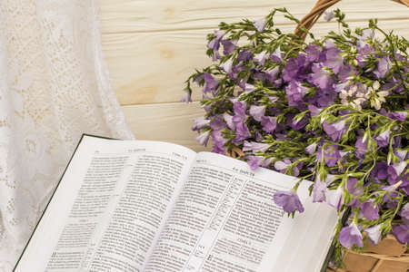Open Bible and bouquet flax in wicker basket. Retro style, vintage