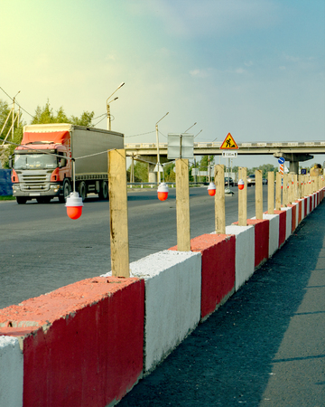 Highway repair. Red safety lights installed on concrete barriers painted red an white.の写真素材
