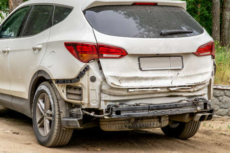 Dusty damaged car after an accident. Vehicle with removed rear bumper and dented back hatch.の写真素材