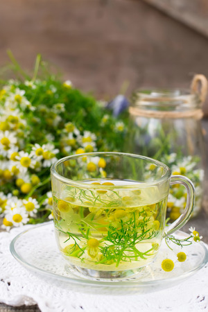 Chamomile tea in a glass cup on a wooden backgroundの写真素材