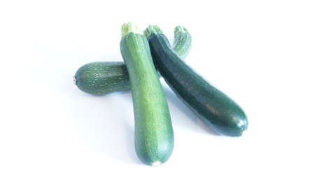 Green zucchini lays on a white backgroundの写真素材