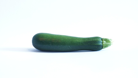 Green zucchini lays on a white backgroundの写真素材