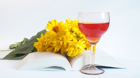 Still Life of yellow flowers, books and A red wine isolated on white backgroundの写真素材