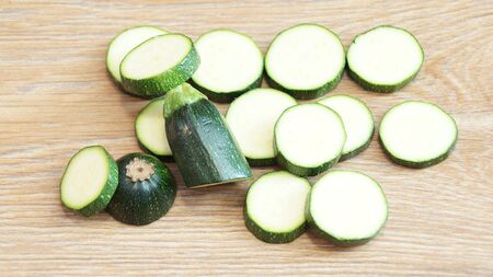 Fresh green zucchini are isolated on a wooden tableの写真素材
