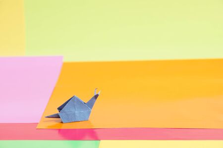 Paper origami snail isolated on a colorful backgroundの写真素材