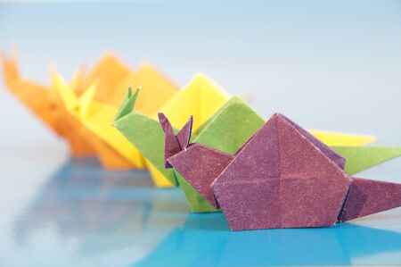 Paper origami snail isolated on a colorful background