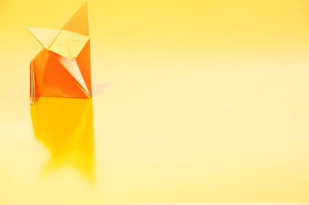 Paper origami fox isolated on a colorful backgroundの写真素材