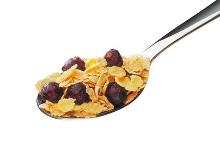 Cornflakes with fruits on the spoon isolated white 