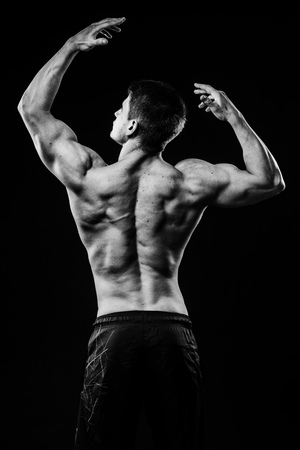 Young strong athlete on dark background isolatedの写真素材