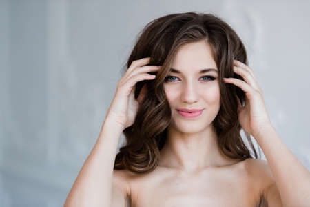 cheerful girl holding her beautiful curly hairの写真素材