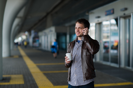 View of a Young attractive man drinking coffee on his wayの写真素材