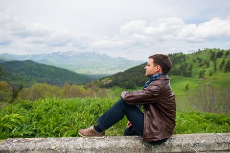 Male hiker relaxing on top of a mountain. Outdoors shot in the mountainsの写真素材