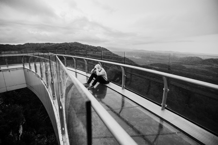 Tourist sit on peak of sandstone rock in the mountains.の写真素材