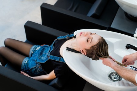 Beautiful woman getting a hair wash in a beauty salon.の写真素材